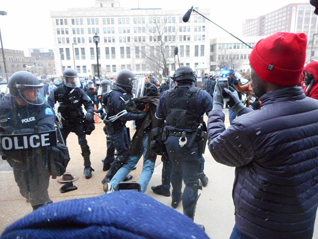 A police police arrests a protester outside city hall, after they declared the non-violent protest an unlawful assembly. (Photo:  Larry Everest / revcom.us)