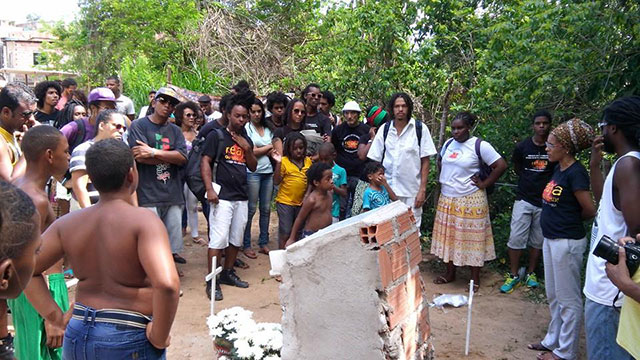 Community Members from Vila Moises Stand with Organizers from React or Die! and Quilombo Xis at the Memorial to the Cabula 12. (Photo: Lena Azevedo)