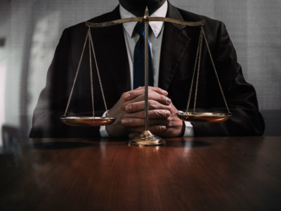 Lawyer seated behind scales of justice