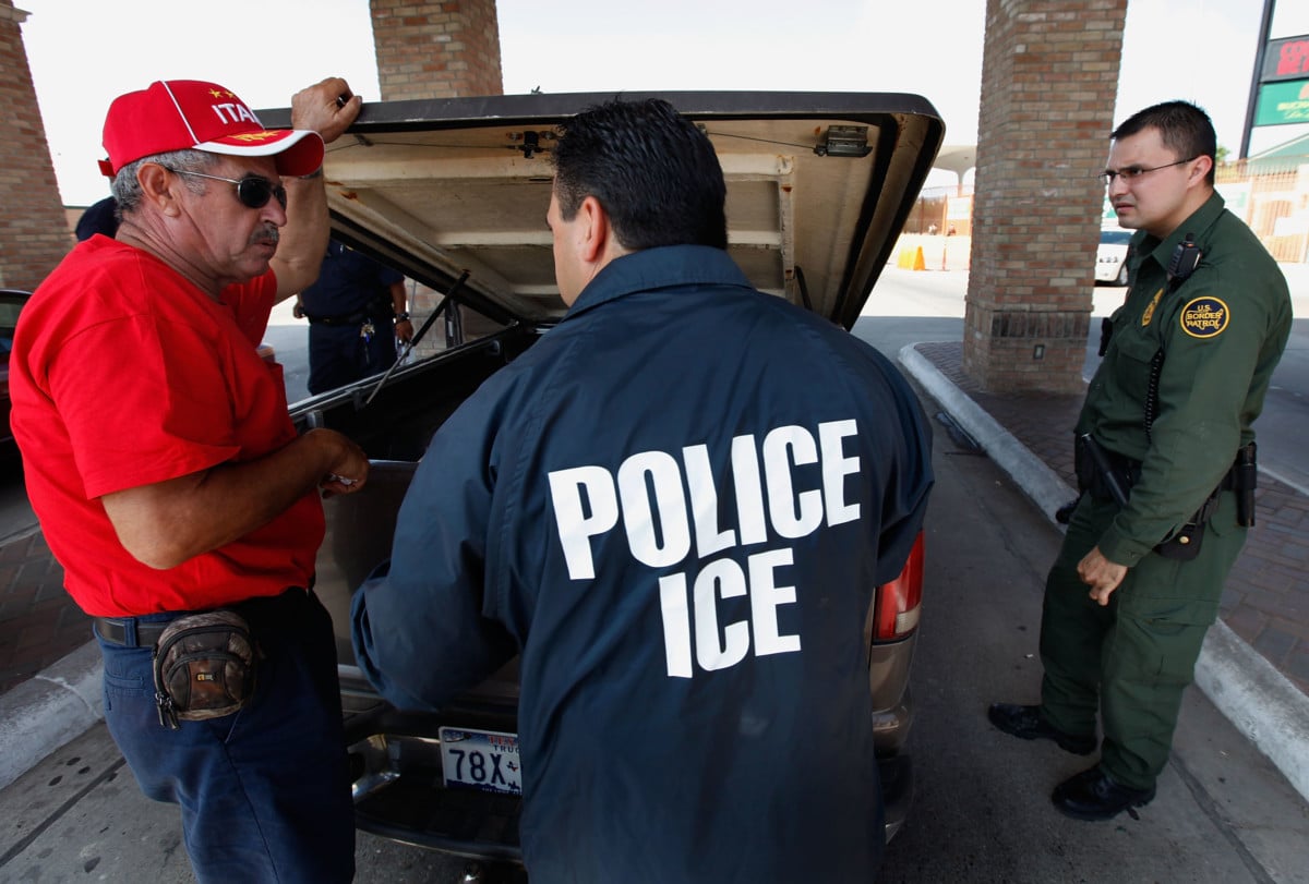 Special agents from Immigration and Customs Enforcement (ICE), Border Patrol, and Customs and Border Protection (CBP) question a man while his vehicle is searched after he was stopped heading into Mexico at the Hidalgo border crossing on May 28, 2010 in Hidalgo, Texas.
