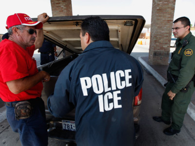 Special agents from Immigration and Customs Enforcement (ICE), Border Patrol, and Customs and Border Protection (CBP) question a man while his vehicle is searched after he was stopped heading into Mexico at the Hidalgo border crossing on May 28, 2010 in Hidalgo, Texas.