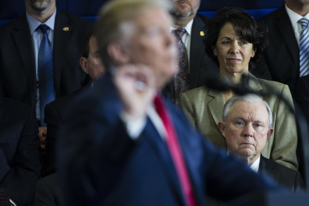 US Attorney General Jeff Sessions listens as Donald Trump delivers a speech at Manchester Community College in Manchester, New Hampshire, on March 19, 2018.