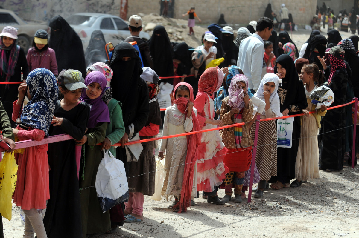 Yemeni war-affected women and girls queue to receive the dinner meal provided by a local charity group on June 10, 2018 in Sana’a, Yemen.