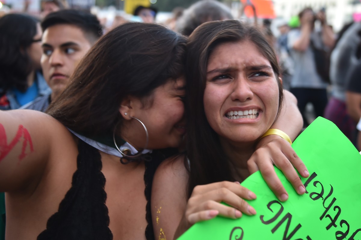 Protestors comfort each other during a "Families Belong Together March" against the separation of children of immigrants from their parents, in Los Angeles, California, on June 14, 2018.
