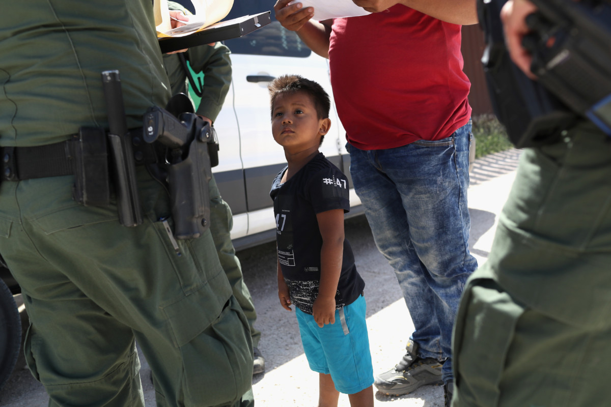 A boy and father from Honduras are taken into custody by US Border Patrol agents near the US-Mexico Border on June 12, 2018, near Mission, Texas. The asylum seekers were then sent to a US Customs and Border Protection processing center for possible separation.