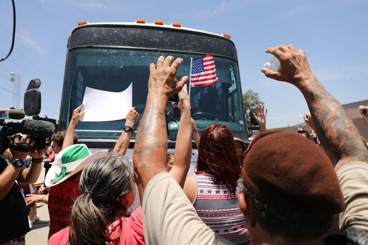 Protesters against the Trump administration's border policies try to block a bus carrying migrant children out of a US Customs and Border Protection Detention Center on June 23, 2018 in McAllen, Texas.