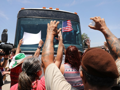 Protesters against the Trump administration's border policies try to block a bus carrying migrant children out of a US Customs and Border Protection Detention Center on June 23, 2018 in McAllen, Texas.