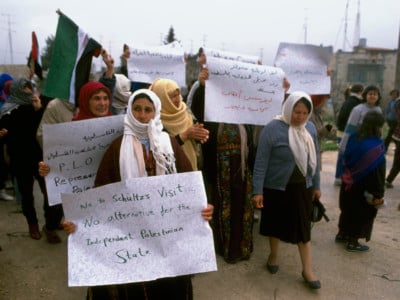 Palestinian women demonstrators carry signs during a protest in Ramallah during the First Intifada.