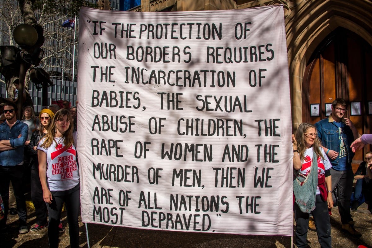 Protesters hold signs at a rally to demand all asylum seekers and refugees be brought to Australia following the Papua New Guinea government's decision to close its refugee camp. In August, leaked Nauru files made shocking revelations regarding child abuse at the Nauru detention center.