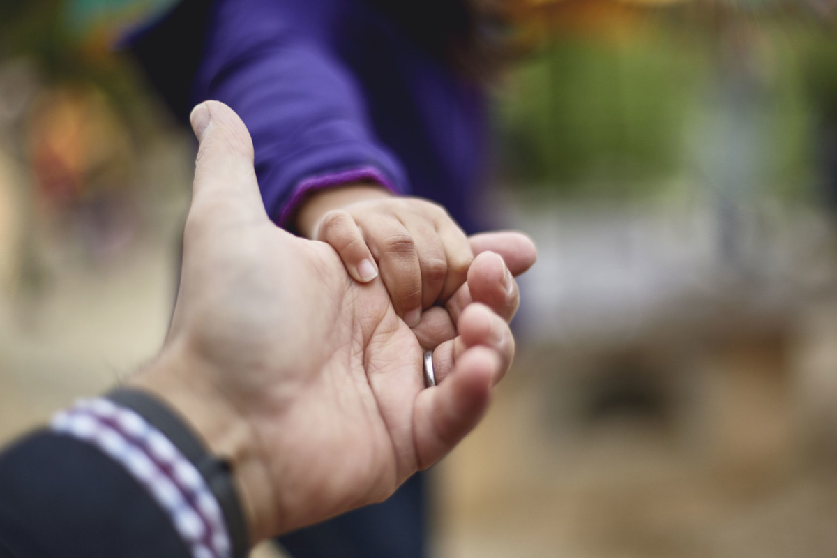 Parent and child hold hands