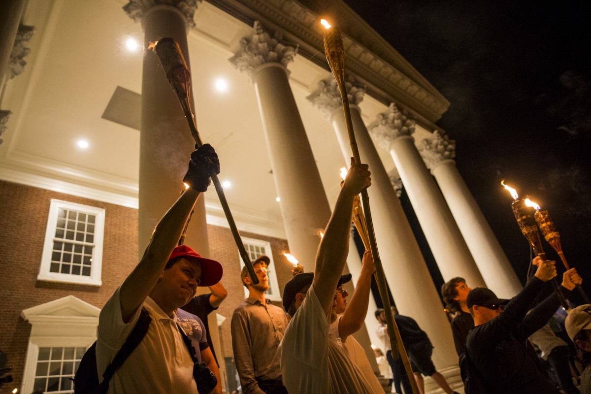 Young men hold up torches on the steps of the rotunda as other Neo Nazis, Alt-Right, and White Supremacists march through the University of Virginia Campus with torches in Charlottesville, Virginia, on August 11, 2017.