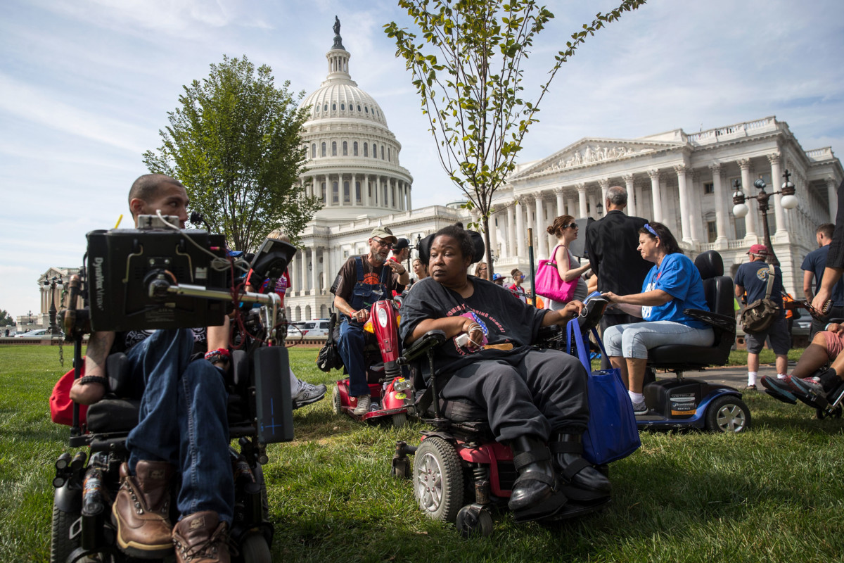 People in wheelchairs, from the group ADAPT, wait for senators to arrive for a news conference in opposition to the Graham-Cassidy health care bill, September 26, 2017, in Washington, DC.