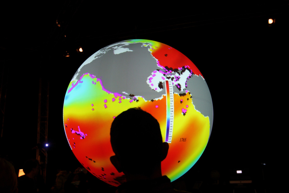A man watches an animated projection showing different acidity levels in the ocean, inside the US Center 09 during the second day of the United Nations climate change conference on December 8, 2009, in Copenhagen, Denmark.