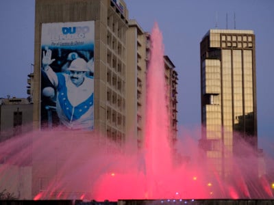 The colored fountain on Plaza Venezuela in front of a giant portrait of President Nicolas Maduro.