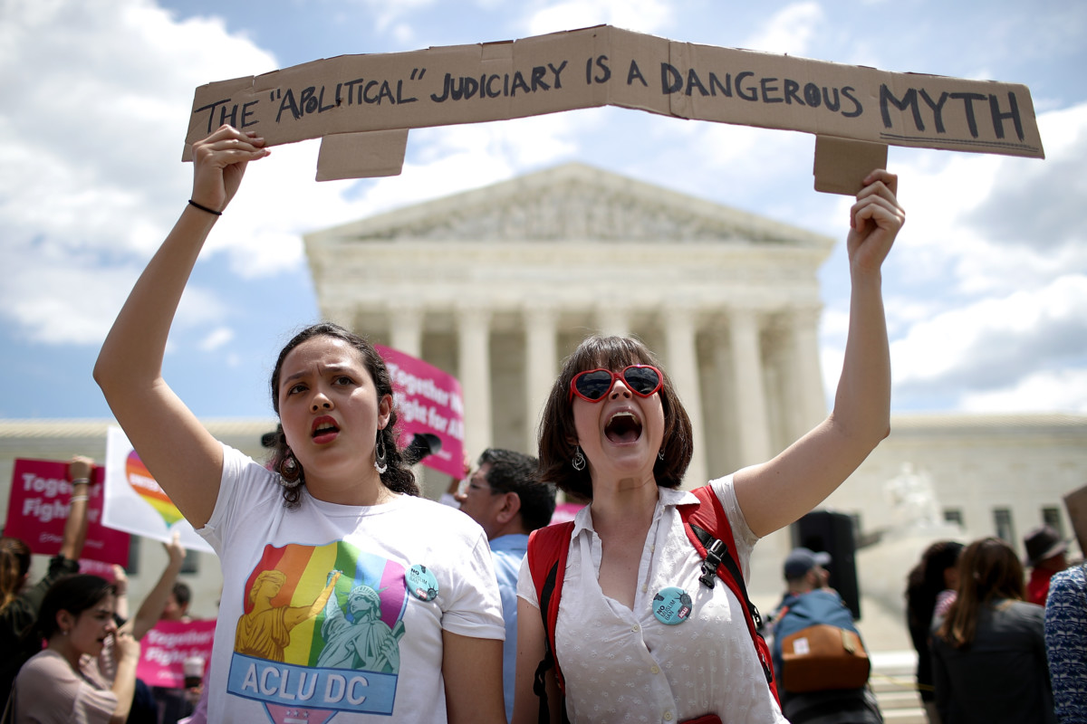 Protesters and Lisset Pino and Celina Scott-Buechler demonstrate against President Trump's travel ban as protesters gather outside the Supreme Court following a court-issued immigration ruling June 26, 2018, in Washington, DC.