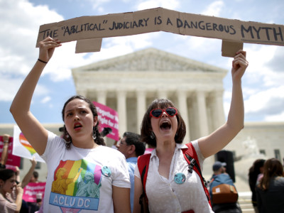Protesters and Lisset Pino and Celina Scott-Buechler demonstrate against President Trump's travel ban as protesters gather outside the Supreme Court following a court-issued immigration ruling June 26, 2018, in Washington, DC.