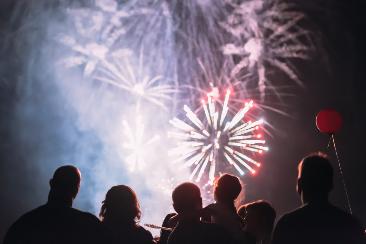 A crowd watches fireworks together