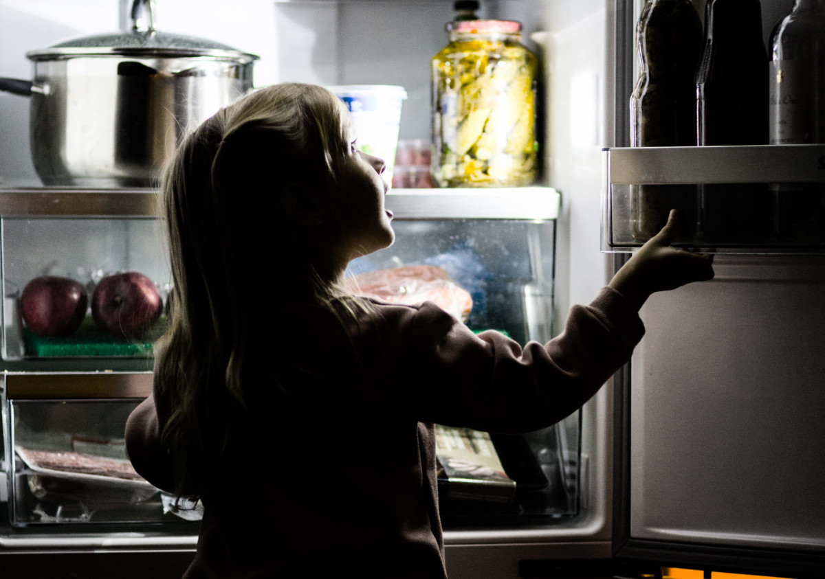 Child looking into refrigerator