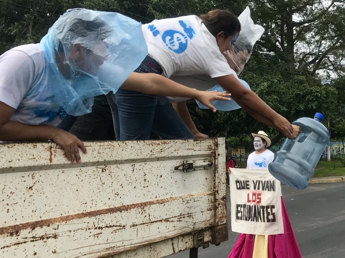 Artists present a theatrical performance representing the threat of water privatization and water shortages during a march for water rights in San Salvador, July 5, 2018.