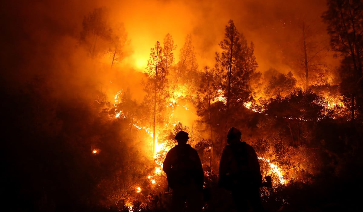 Firefighters monitor a back fire as they battle the Medocino Complex fire on August 7, 2018, near Lodoga, California. Verizon has admitted to throttling the Santa Clara County Fire Department's data speed as it fought the fire.
