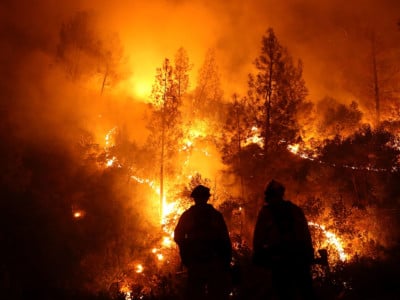 Firefighters monitor a back fire as they battle the Medocino Complex fire on August 7, 2018, near Lodoga, California. Verizon has admitted to throttling the Santa Clara County Fire Department's data speed as it fought the fire.
