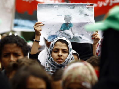A Yemeni girl raises a poster during a demonstration in Sanaa on August 12, 2018, against an airstrike by the Saudi-led coalition that hit a bus, killing dozens of children in the northern Huthi stronghold of Saada.