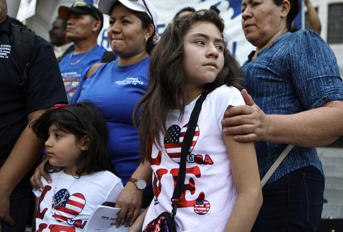 Mother Mily Rivas (top, center-left), a Temporary Protected Status (TPS) recipient from El Salvador, stands with her daughters Suri and Ariely Murrilo, both US citizens, at the launch of the "TPS Journey for Justice Caravan" outside City Hall on August 17, 2018, in Los Angeles, California. Mily faces deportation with the termination of the TPS program for Salvadorans.