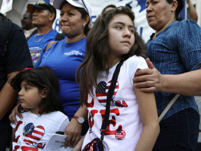 Mother Mily Rivas (top, center-left), a Temporary Protected Status (TPS) recipient from El Salvador, stands with her daughters Suri and Ariely Murrilo, both US citizens, at the launch of the "TPS Journey for Justice Caravan" outside City Hall on August 17, 2018, in Los Angeles, California. Mily faces deportation with the termination of the TPS program for Salvadorans.