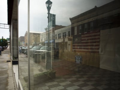 A USA flag hangs in the window of a vacant building in downtown Keyser, West Virginia.