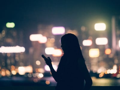 Woman on cell phone in front of city