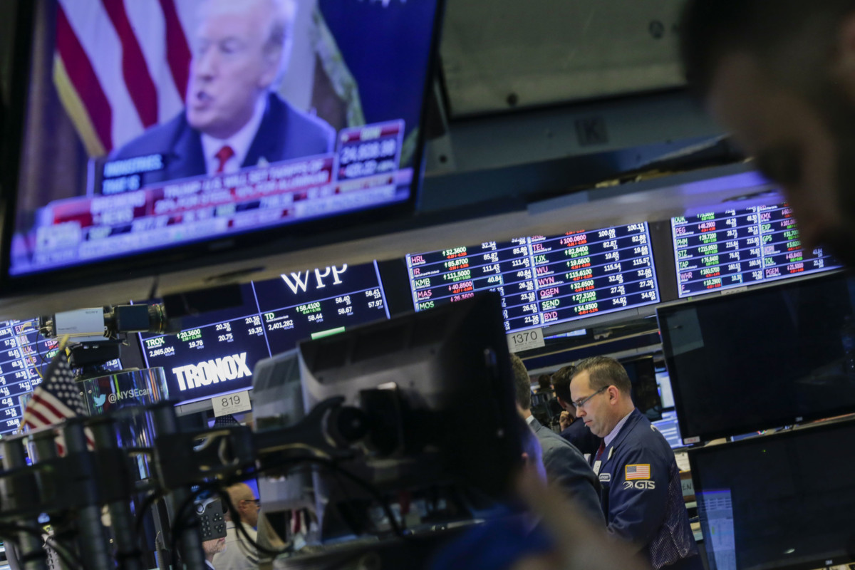 Traders work on the floor of the New York Stock Exchange as President Trump is seen on TV on March 1, 2018, in New York City.