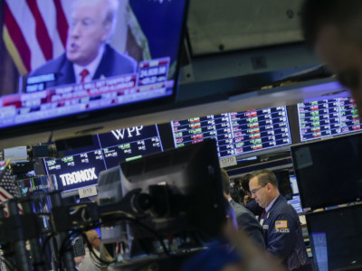 Traders work on the floor of the New York Stock Exchange as President Trump is seen on TV on March 1, 2018, in New York City.