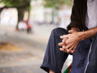 Elderly man sitting with hands together