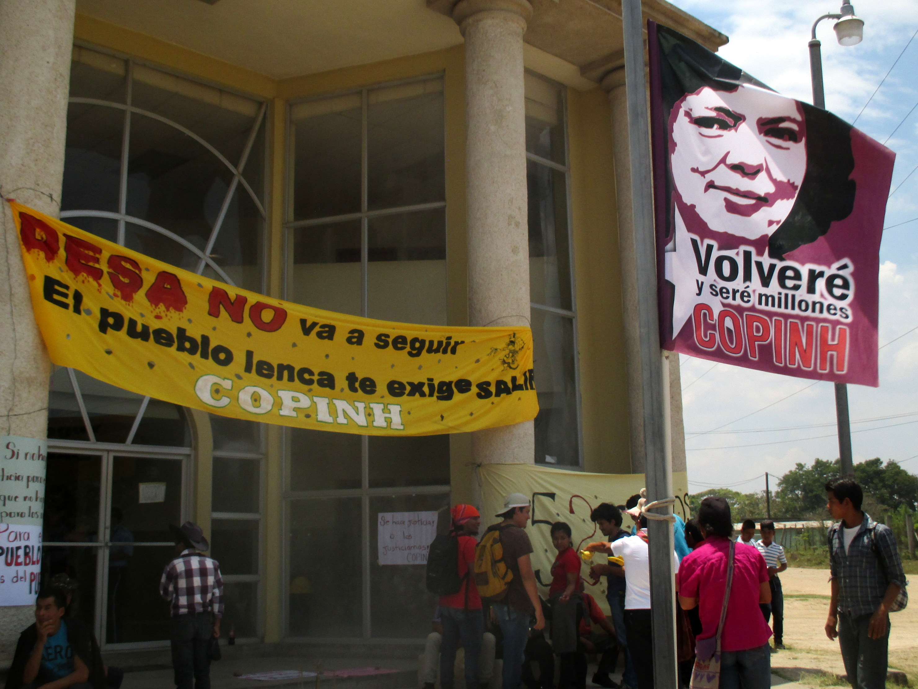 "I will return, and I will be millions," reads a flag with Berta Cáceres's image outside the Siguatepeque courthouse during an April court case related to the authorization of the Agua Zarca dam.