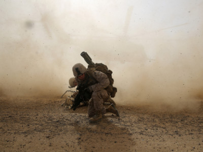 U.S. Marine Corps Cpl. Daniel Hopping, an assaultman with Weapons Company, 1st Battalion, 7th Marine Regiment, shields himself from dust being kicked up from a CH-53E Super Stallion helicopter lifting off April 28, 2014, during a mission in Helmand province, Afghanistan.