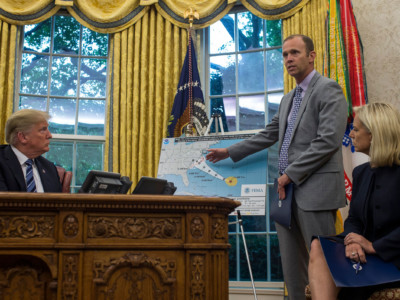 Brock Long, administrator of the Federal Emergency Management Agency, speaks in the Oval Office at the White House September 11, 2018, in Washington, DC, after briefing President Trump on Hurricane Florence. Seated at right is US Secretary of Homeland Security Kirstjen Nielsen.