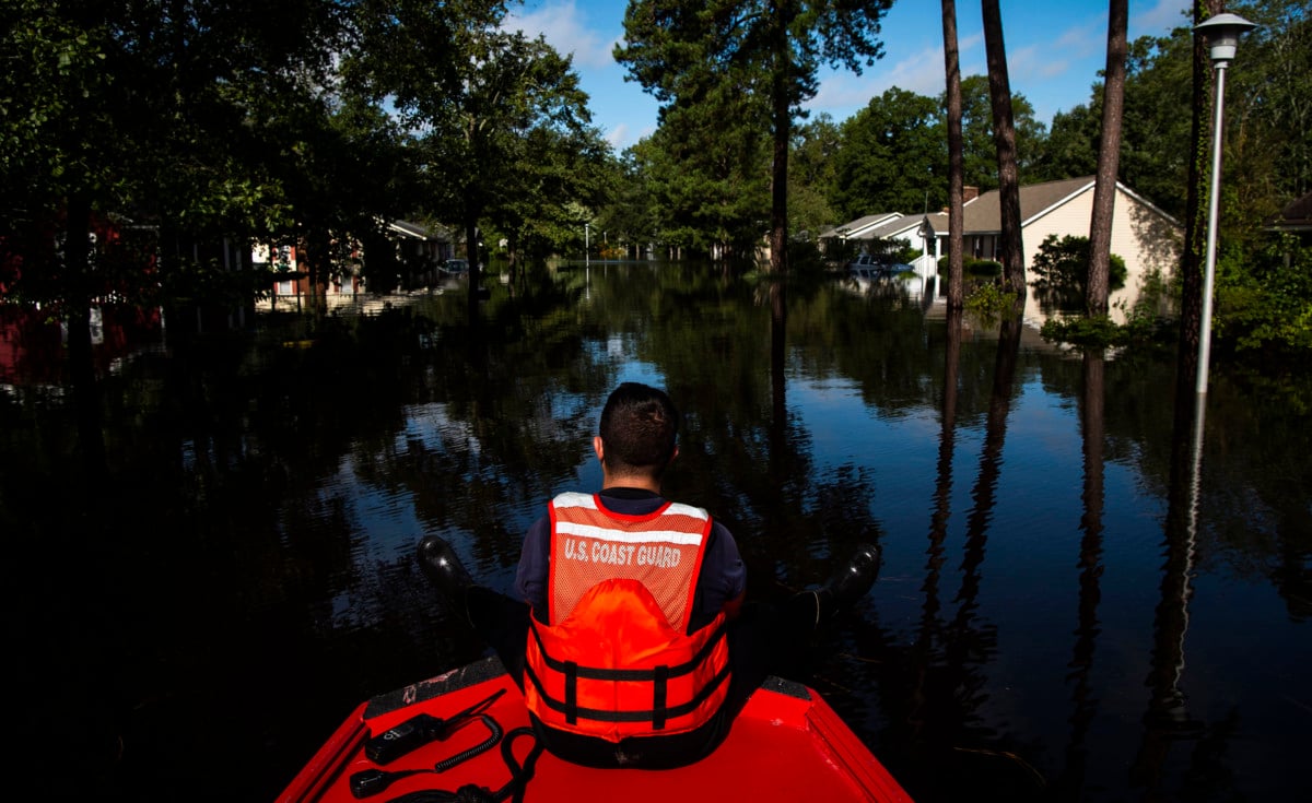 Boatswain's Mate Dimitri Georgoulopoulos looks out as members of a punt team with the Coast Guard perform searches through flood waters in the MayFair neighborhood in the aftermath of Hurricane Florence on September 17, 2018, in Lumberton, North Carolina.