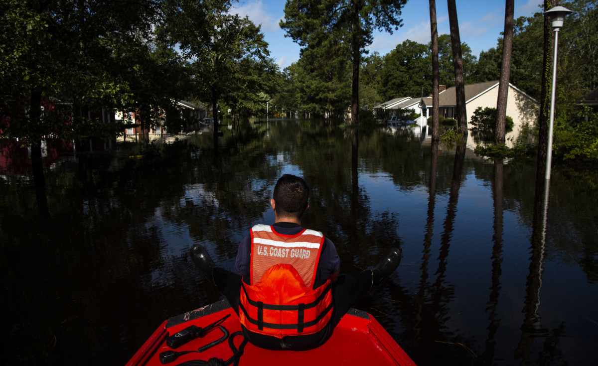 Boatswain's Mate Dimitri Georgoulopoulos looks out as members of a punt team with the Coast Guard perform searches through flood waters in the MayFair neighborhood in the aftermath of Hurricane Florence on September 17, 2018, in Lumberton, North Carolina.