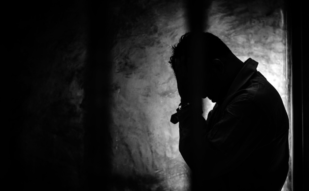 Prisoner with head in hands