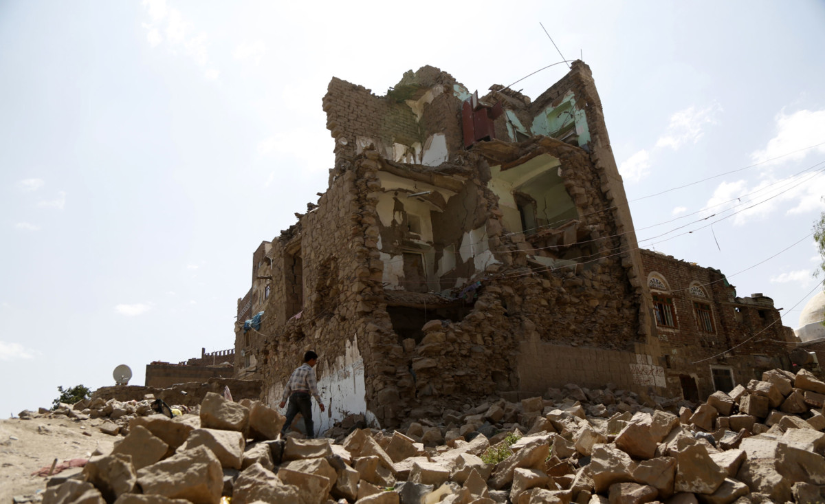 A boy walks by a house destroyed in an airstrike carried out by a Saudi-led coalition warplane in 2018 in Sana'a, Yemen.