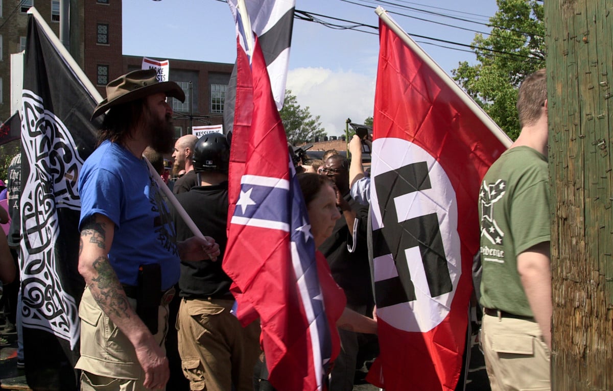 Demonstrators carry Confederate and Nazi flags during the "Unite the Right" rally at Emancipation Park in Charlottesville, Virginia, on August 12, 2017.