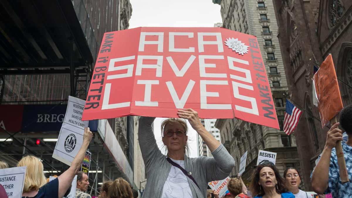 Participants hold signs while protesting the repeal and replacement of the Affordable Care Act during a rally on July 29, 2017.