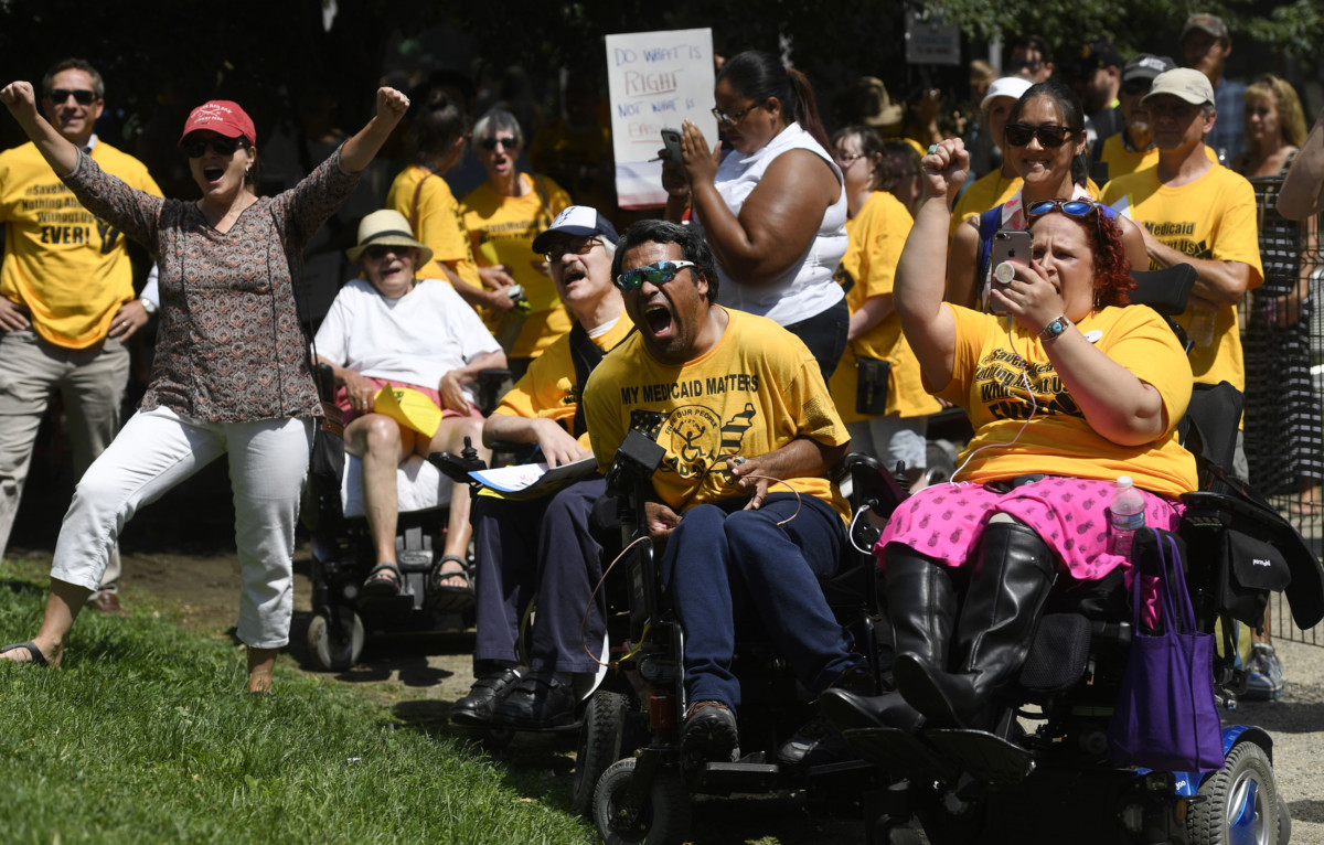 Disabled activist Jose Torres-Vega with ADAPT, center, leads protesters in a chant at the Save Medicaid Rally at Skyline Park near Sen. Cory Gardner's Denver office July 6, 2017, in Denver.