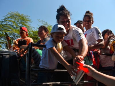 Honduran refugees aboard a truck in the migrant caravan headed to the US receive food donations in Acacoyagua, Chiapas State, Mexico, on October 24, 2018.
