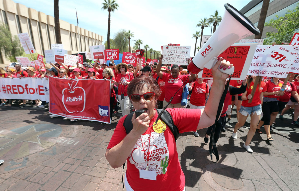 Teachers march through downtown Phoenix on their way to the State Capitol during a rally for the #REDforED movement on April 26, 2018, in Phoenix, Arizona.