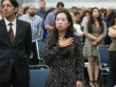 US Army veteran Yea Ji Sea, originally from South Korea, says the oath of allegiance at a US naturalization ceremony to become US citizen on August 24, 2018, along with more than 3,000 other immigrants at the Los Angeles Convention Center in Los Angeles, California.