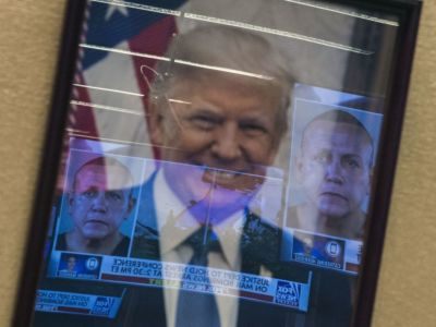 Mugshots of bombing suspect Cesar Sayoc are reflected on a portrait of US President Donald Trump prior to a press conference at the Department of Justice in Washington, DC on October 26, 2018, following the arrest of Sayoc in Florida.