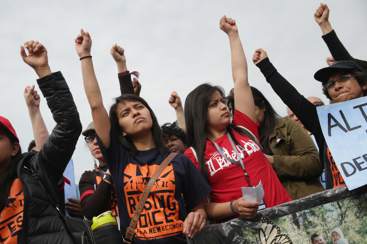 Activists raise fists during a rally organized in part by the National Domestic Workers Alliance in front of the White House to demonstrate against President Obama's immigration and deportation actions on April 28, 2014, in Washington, DC.