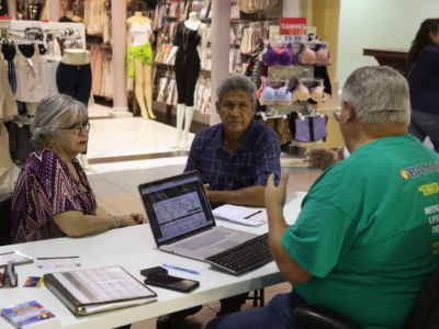 Isabel Diaz Tinoco and Jose Luis Tinoco speak with Otto Hernandez, an insurance agent from Sunshine Life and Health Advisors, as they shop for insurance under the Affordable Care Act at a store set up in the Mall of the Americas on November 1, 2017, in Miami, Florida.