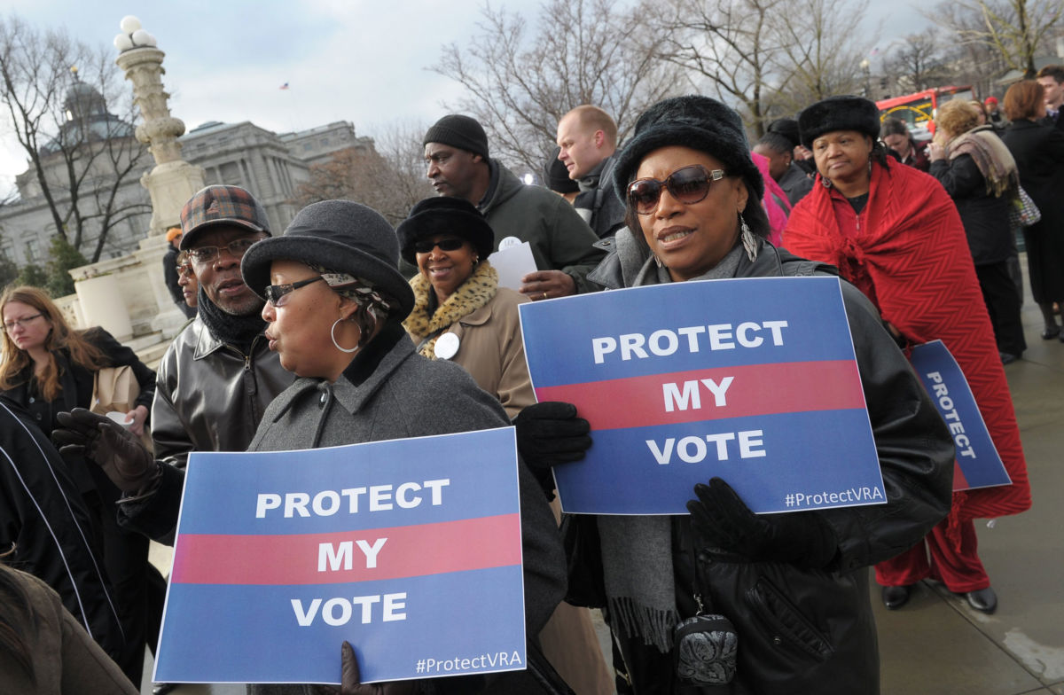 Activists hold pro-voting rights placards outside the US Supreme Court in Washington, DC, on February 27, 2013, as the Court prepared to hear Shelby County vs Holder, which reversed some important provisions of the 1965 Voting Rights Act.